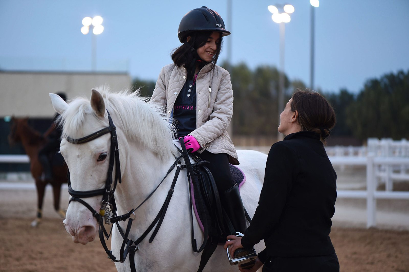 A young rider smiling with her instructor at MEC
